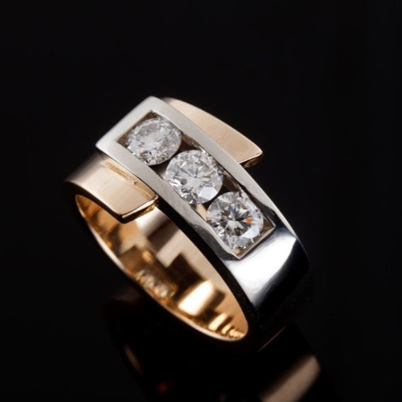 Gold ring with three diamonds on a black background
