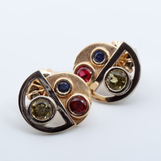 Pair of gold earrings with colored gemstones on a white background